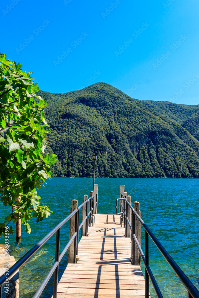 Wooden pier overlooking the Alps and Lake Lugano in Switzerland