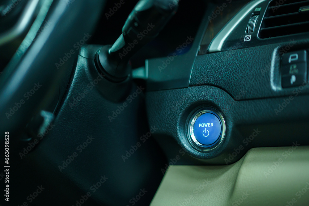 Close up of engine start button in the modern electric vehicle or EV. Car engine start button in blue color close up.