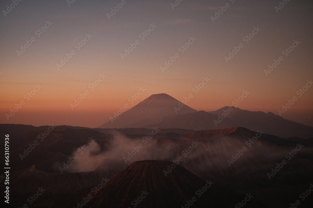 Ethereal Dawn: Bromo's Sunrise Amidst Warm Clouds