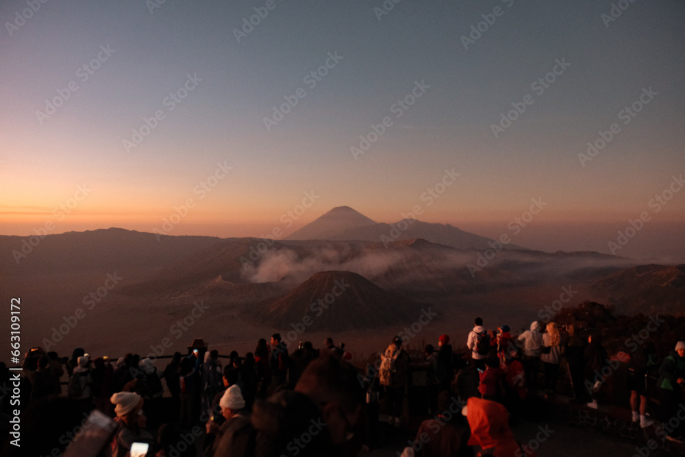 Fototapeta premium Crowded Awe: Bromo's Sunrise Embraces Enthralled Crowd