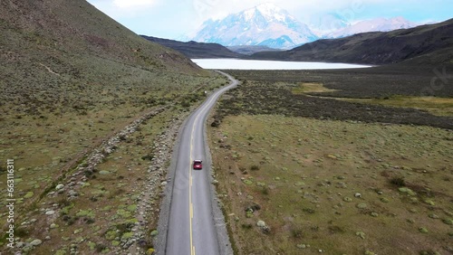 Smooth drone flight in Patagonia with a car on a long road leading to the mountains. photo