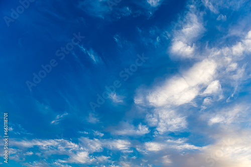 Landscape with Altocumulus and Cirrocumulus white clouds against a beautiful blue sky background. The beauty clear cloudy in sunlight calm bright winter, autumn spring or summer windy air background.