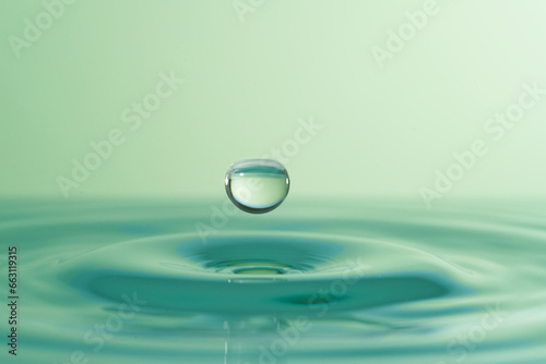 Group of colorful water droplets fall and bounce on a water surface