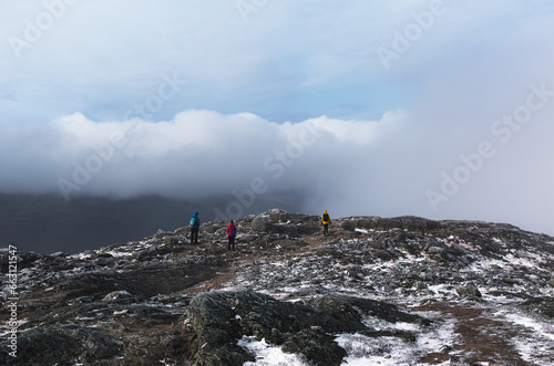 Group of hikers standing on top of a mountain Saana in Finland