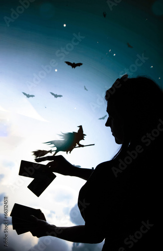 Foto the black shadow of a girl in profile with Tarot cards in hand cards in the back