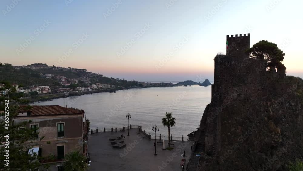 Aci Castello e sullo sfondo le isole Ciclopi di Acitrezza. Sicilia, Italia, 
Vista aerea all'alba della costa vulcanica siciliana tra Aci Castello e Acitrezza.