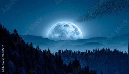 Silhouette of birds flying over blue mountains - Beautiful landscape with blue misty silhouettes of mountains against super blue moon rising "Elements of this image furnished by NASA"