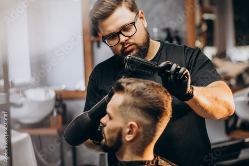 Handsome man at a barber shop styling hair