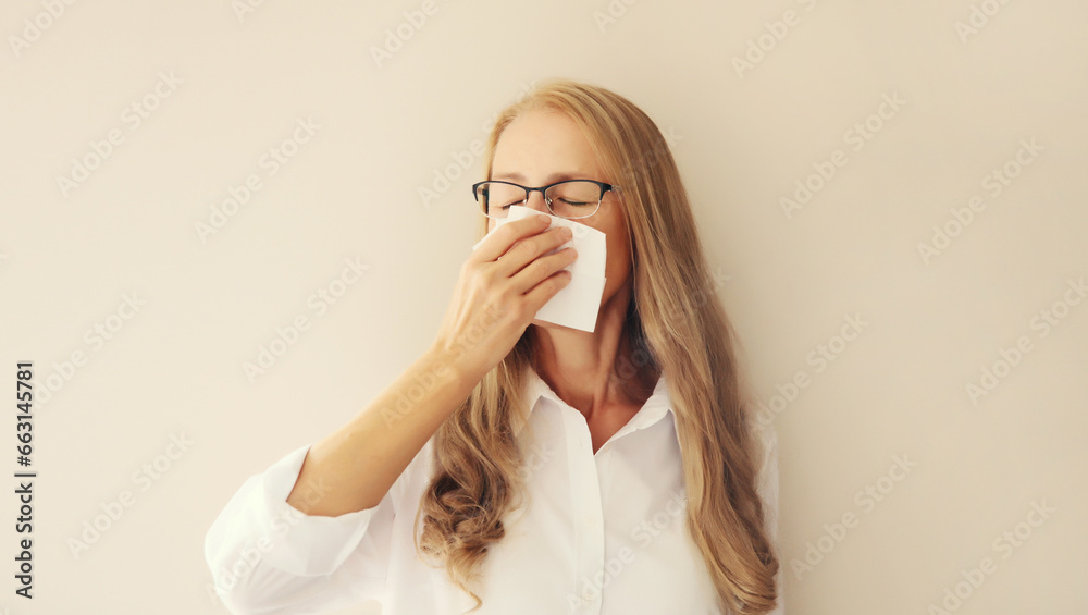 Sick exhausted middle-aged woman employee sneezing blow nose using tissue Sick exhausted middle-aged woman employee sneezing blow nose using tissue