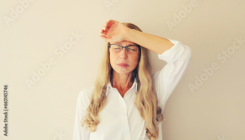 Photography Tired overworked middle-aged woman employee with headache, closed eyes touches h