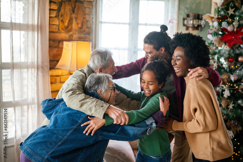 Excited multiethnic family greeting grandparents on Christmas Day. Multi-generational happy family photo