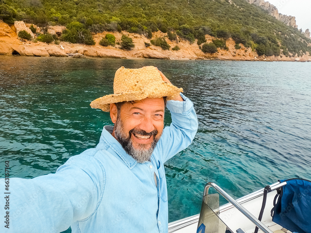 One cheerful happy man with excited expression on face taking selfie picture standing inside a boat during sea excursion tour in summer holiday travel vacation. Male people enjoying life and tourism