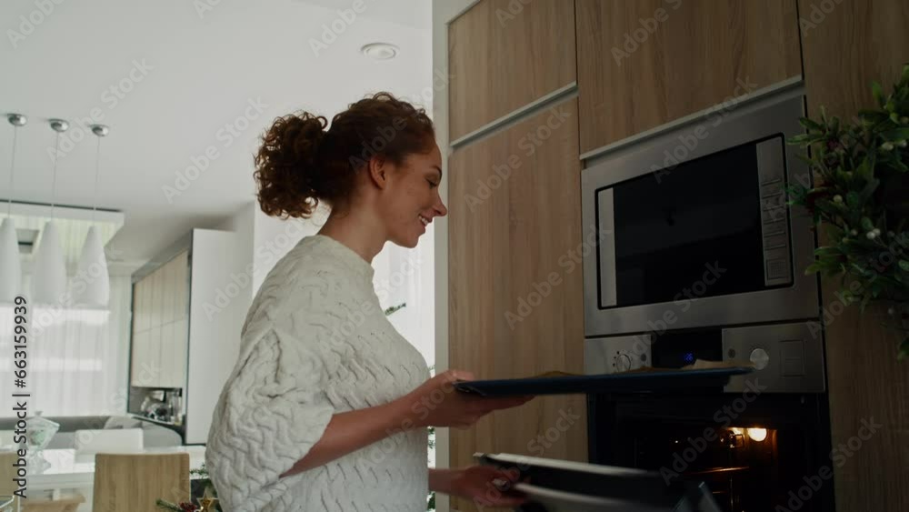 Caucasian woman baking gingerbread cookies for Christmas in the oven. Shot with RED helium camera in 8K. 
