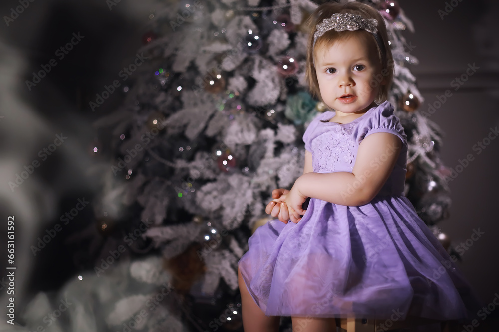 Child in smart clothes in front of the Christmas tree. New Years Eve. Waiting for the new year. Child in smart clothes in front of the Christmas tree. New Years Eve. Waiting for the new year.