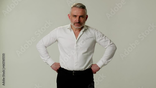 A middle aged man boss is angry with a murderous look. Ready to scold subordinate. A businessman in aggressive pose and with emotions of indignation waits for explanation of the reasons for lost in a