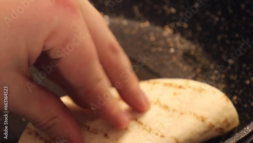 A chef fries a tortilla with tender beef and cheese as part of the step-by-step process of preparing Quesabirria tacos, a delicious Mexican dish photo