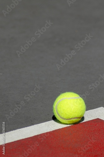Vibrant yellow Tennis ball against the stark white court line © Wirestock
