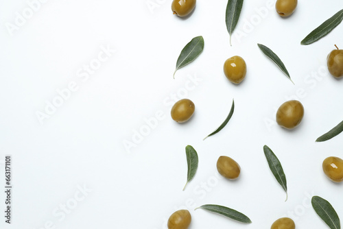Olives with fresh leaves on a light background