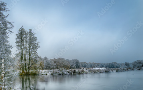 Frozen lake in northern German countryside after snowfall in winter