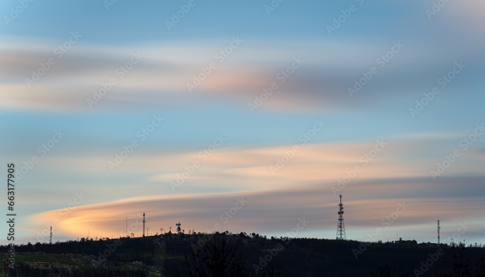 Long Exposure of Communication Antennas Silhouette On Mountain During Dusk