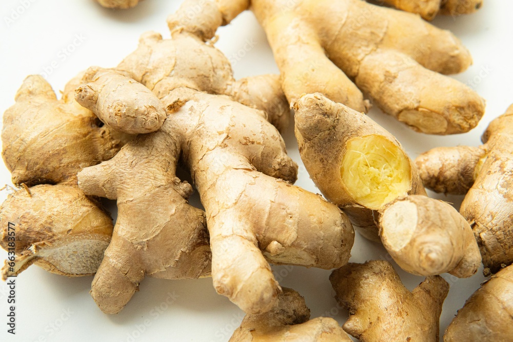 fresh ginger root on white table with one cut in half fresh ginger root on white table with one cut in half