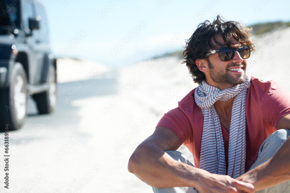 Smile, happy man sitting in desert and road trip with freedom, car travel and adventure for summer vacation. Transport, holiday journey and smile, person with van in road nature, sunshine and relax.