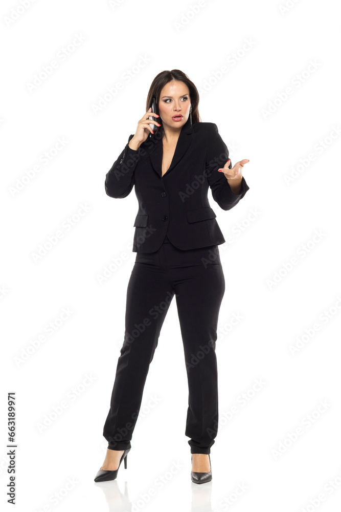 Nervous business woman standing in the white studio and talking on mobile phone. Nervous business woman standing in the white studio and talking on mobile phone.