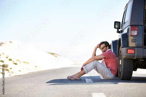 Problem, desert and man at car on road trip with emergency, travel and desert adventure for vacation. Transport, stress on journey and driver waiting on floor at van with breakdown, suv and relax.