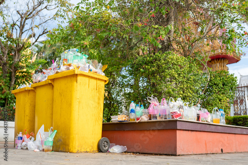 Garbage bins are overflowing since there are not enough receptacles and bins to handle the flow of waste for that area.