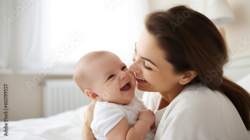 Happy, cheerful ethnic mom holds a laughing baby daughter in her arms