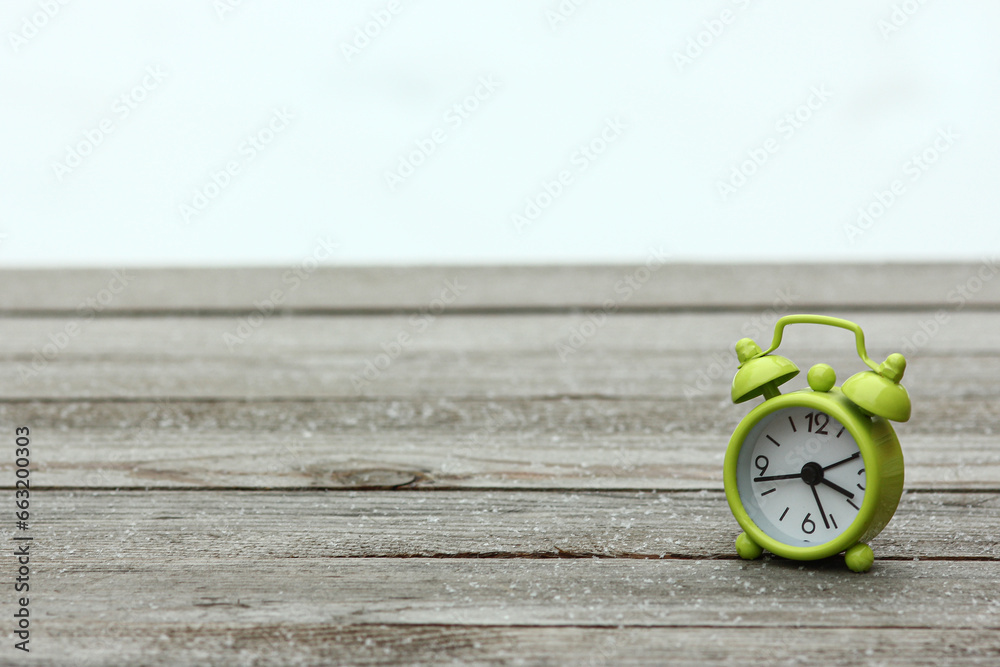 beautiful alarm clock in winter on nature in the park celebrations background