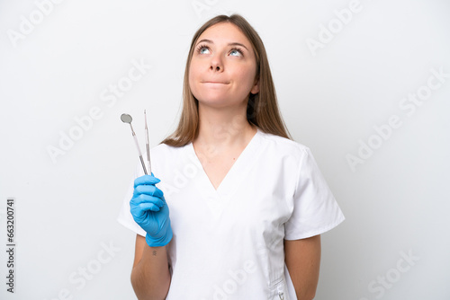 Dentist woman holding tools isolated on white background and looking up