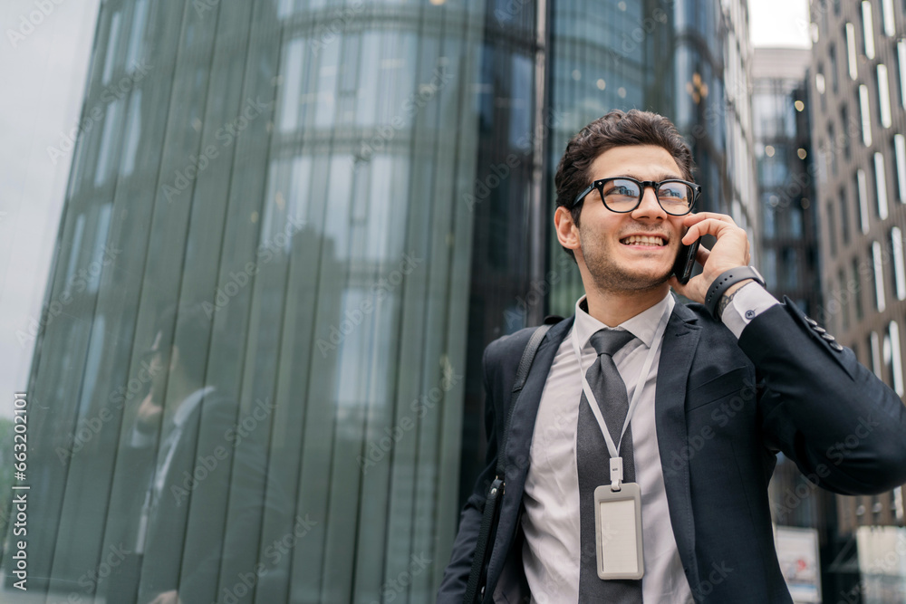 Portrait of A confident Man smiling Talking on the phone in a business suit with glasses. A businessman calls a colleague on the phone to discuss a project. Portrait of A confident Man smiling Talking on the phone in a business suit with glasses. A businessman calls a colleague on the phone to discuss a project.