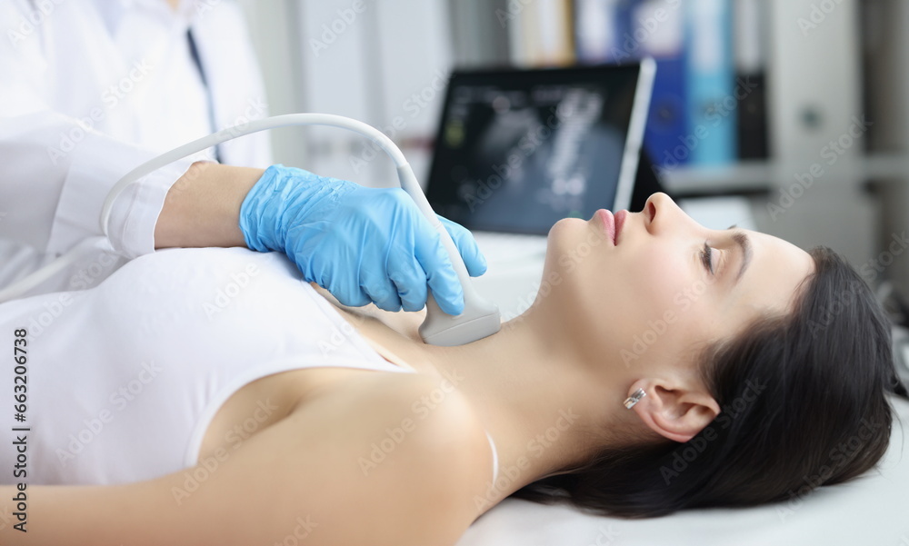 Portrait of ultrasound scanning diagnostic of woman thyroid gland in clinic, doctor runs ultrasound sensor over patients neck with gel. Diagnostics concept