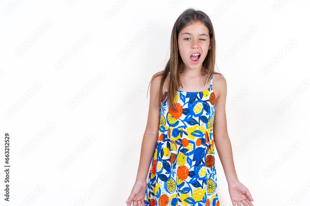 Beautiful little kid girl wearing colorful dress winking looking at the camera with sexy expression, cheerful and happy face.
