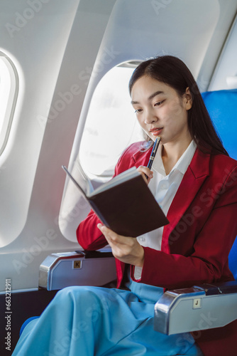 Woman working and update with calendar, schedule, timetable, and management, event planning sitting in airplane.