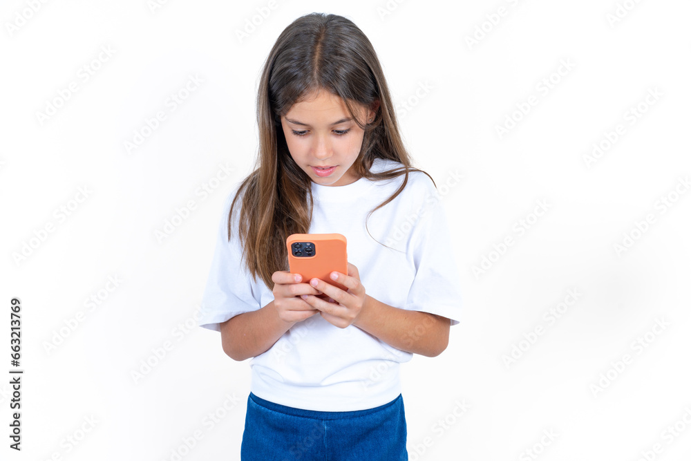 Beautiful kid girl wearing white T-shirt using mobile phone chatting free time . Beautiful kid girl wearing white T-shirt using mobile phone chatting free time .