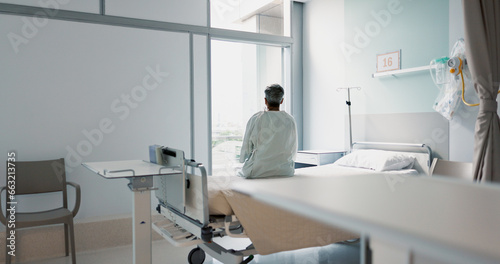Fototapeta Naklejka Na Ścianę i Meble -  Back, healthcare and a woman on a hospital bed by the window in recovery or waiting for a visit. Medical, cancer and a patient thinking about the future of medicine in a health clinic for treatment