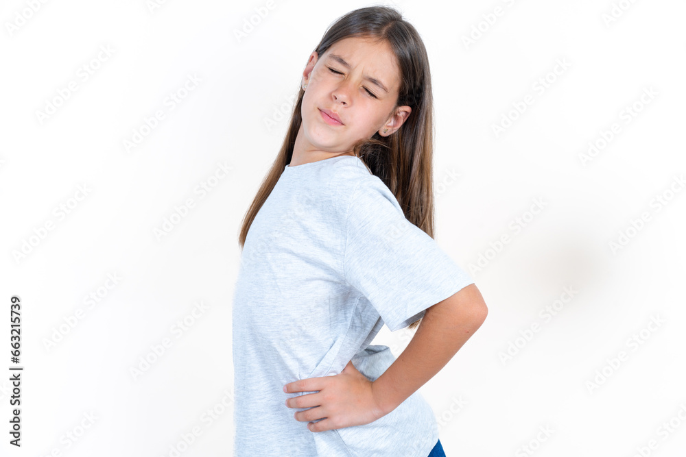 Beautiful little kid girl wearing blue T-shirt got back pain Beautiful little kid girl wearing blue T-shirt got back pain