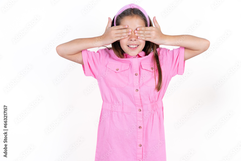 Beautiful little kid girl wearing pink dress covering eyes with hands smiling cheerful and funny. Blind concept. Beautiful little kid girl wearing pink dress covering eyes with hands smiling cheerful and funny. Blind concept.