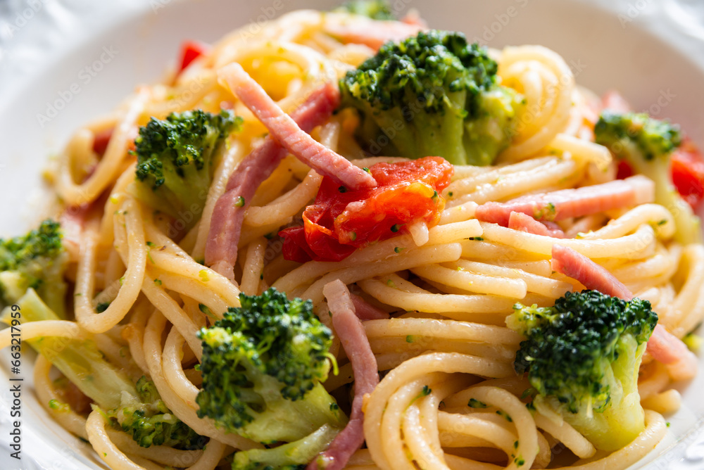 Piatto di deliziosi spaghetti con broccoli, pomodorini e pancetta, cibo italiano Piatto di deliziosi spaghetti con broccoli, pomodorini e pancetta, cibo italiano