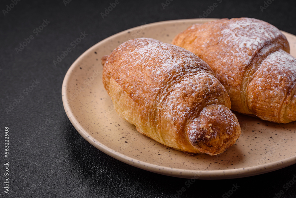 Delicious fresh sweet crispy croissants with chocolate cream on a ceramic plate