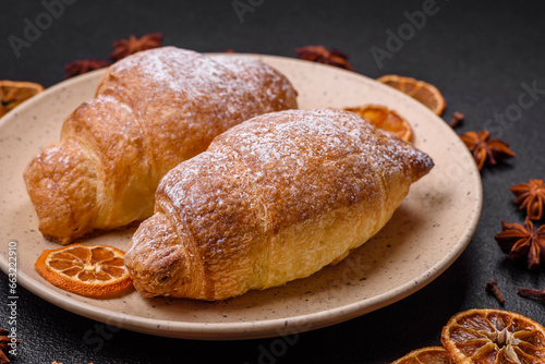 Delicious fresh sweet crispy croissants with chocolate cream on a ceramic plate