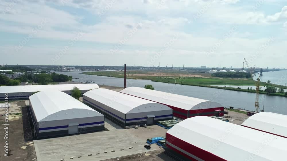 Massive grain storage units near river water, aerial drone view Massive grain storage units near river water, aerial drone view