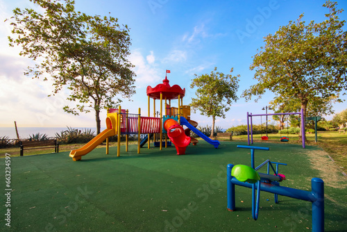 The children's playground is colorful on a green yard. Antalya - Turkey