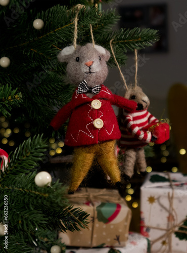 Felted wool mouse on a Christmas tree close-up against a background of gifts