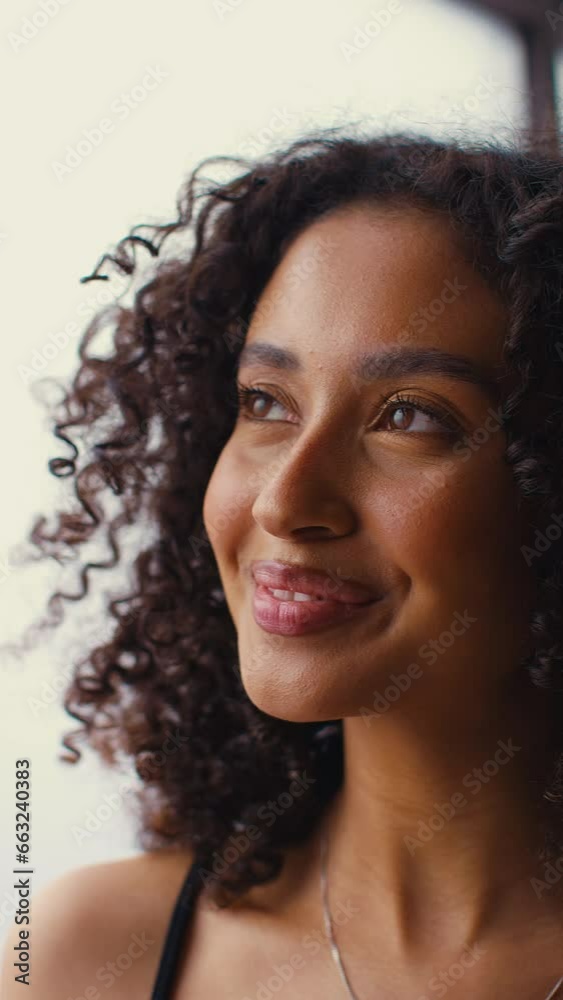 Vertical video close up studio portrait of smiling natural woman standing against neutral background - shot in slow motion Vertical video close up studio portrait of smiling natural woman standing against neutral background - shot in slow motion