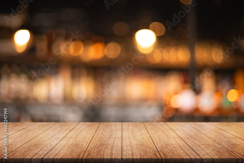 Empty wooden table top with lights bokeh on blur restaurant background.  