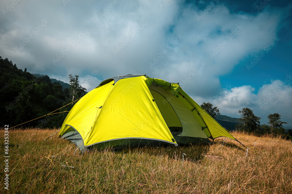 A green tent set up among clouds and greenery. A peaceful camp where you can spend time in touch with nature.