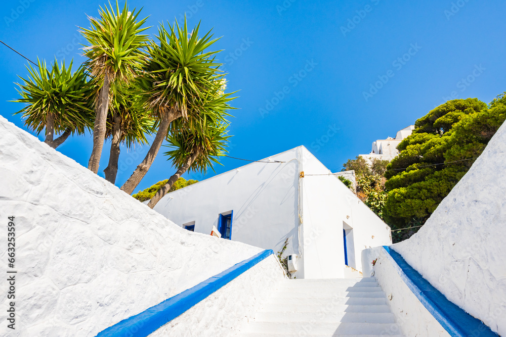 White steps to traditional Greek restaurant with tropical garden in Plaka village, Milos island, Cyclades, Greece